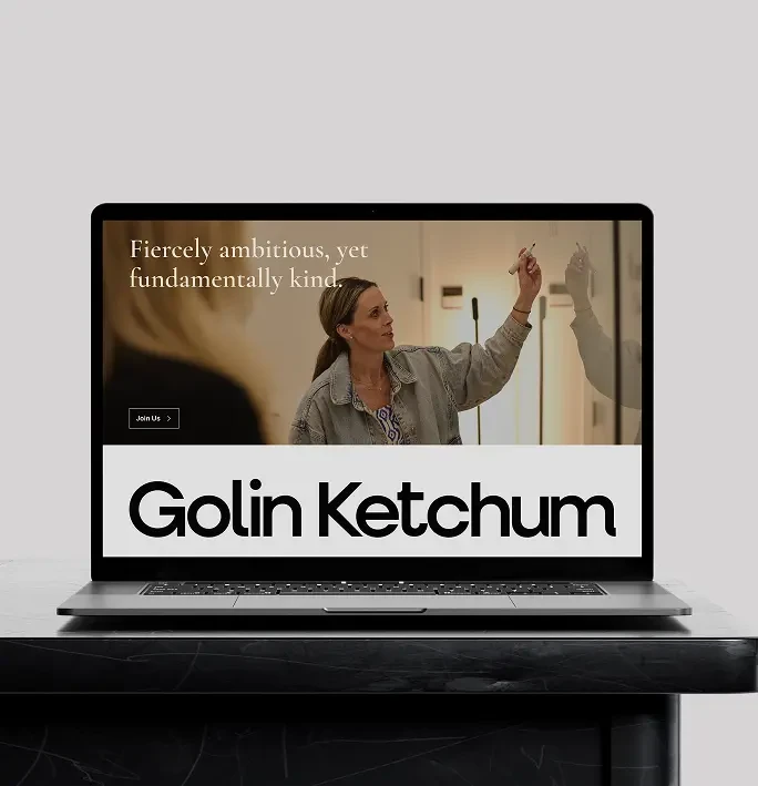 A laptop screen showing Golin Ketchum homepage